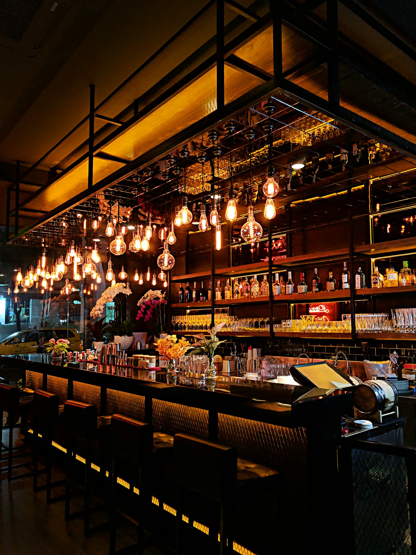 A bar glowing with warm pendant lights